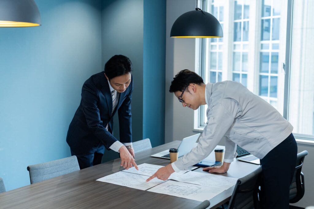 施行に関する打合せをする二人の男性